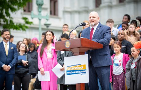 Representative Doyle Heffly standing at podium on Capitol steps and addressing attendees.